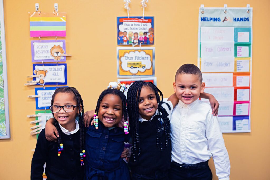 Smiling students standing with arms around each other.
