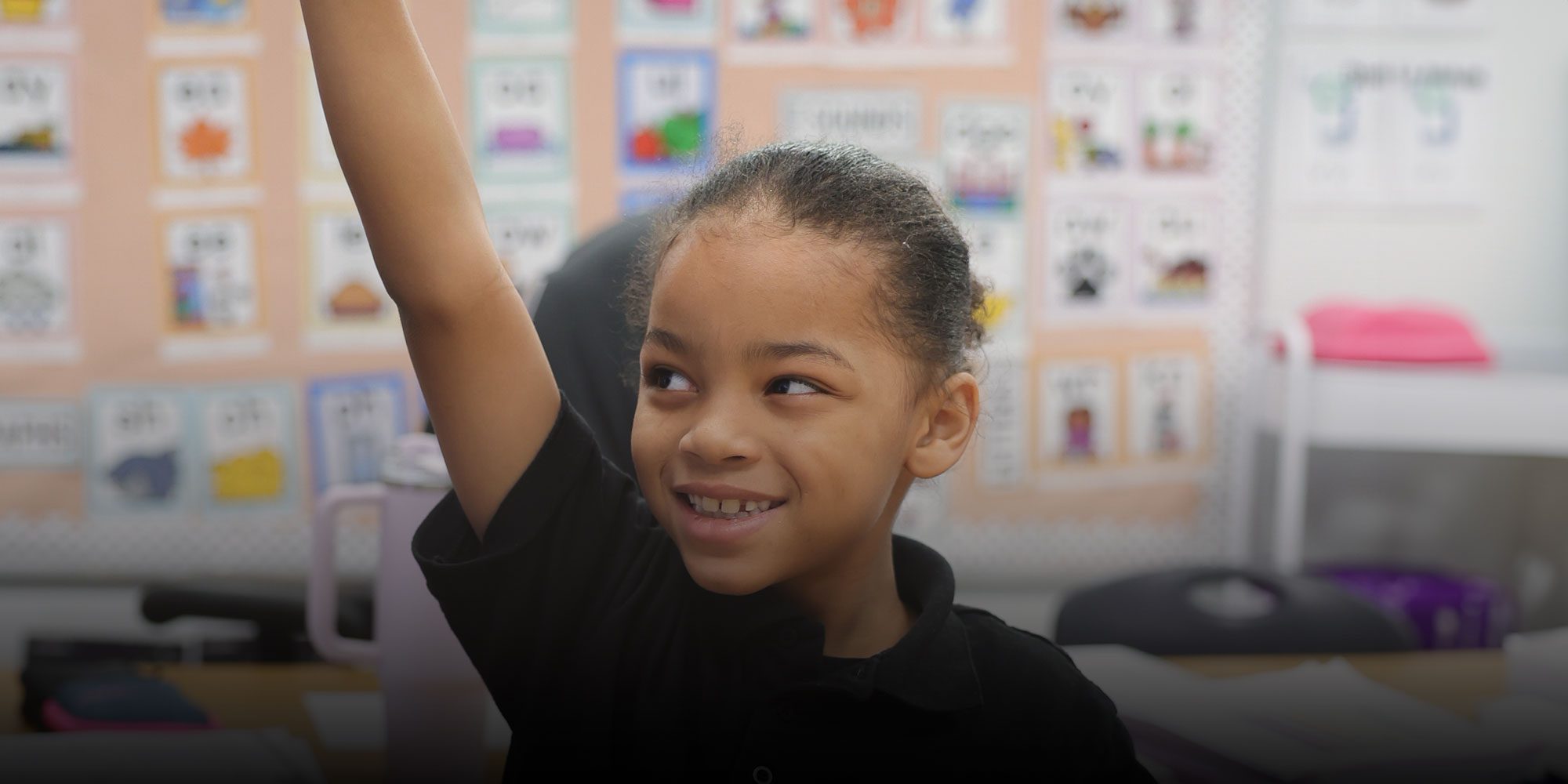 Enthusiastic student raising hand in classroom